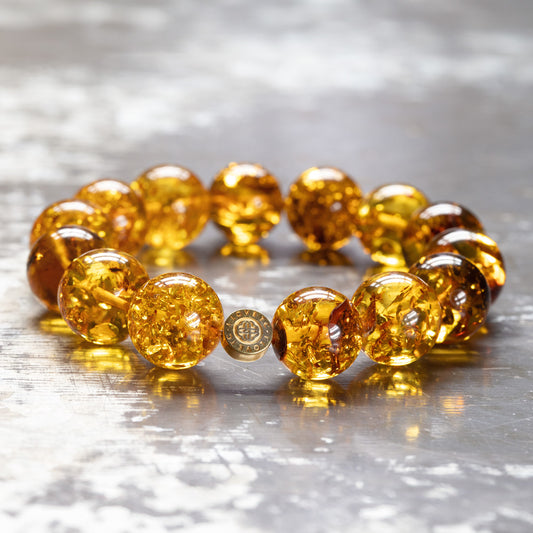 Shiny amber bracelet with gold-plated logo pendant